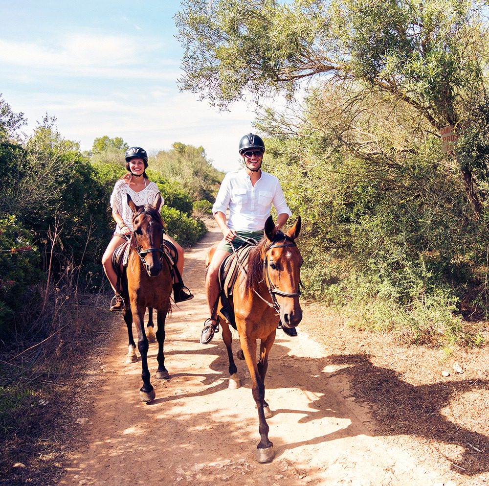 Two people enjoying horse ride outdoors