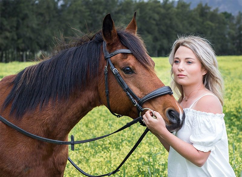Woman with horse in a field