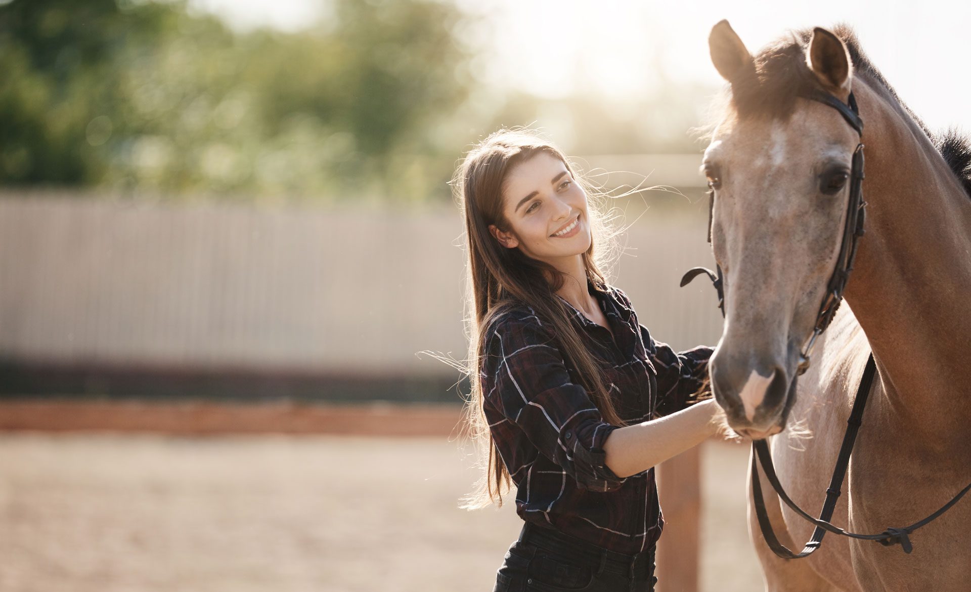 Woman smiling next to horse outdoors